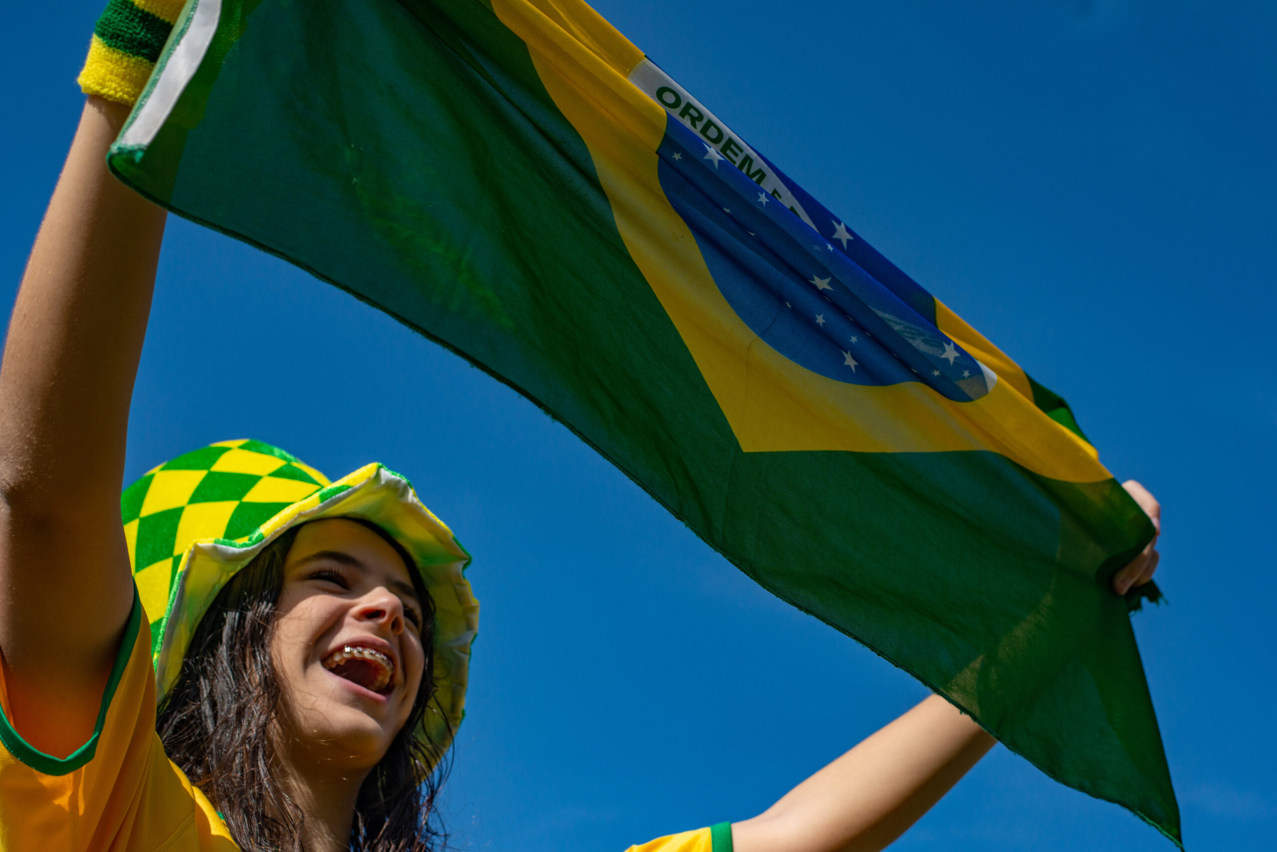 Brazilian fan celebrating and cheering for the Brazil national team at the World Cup.