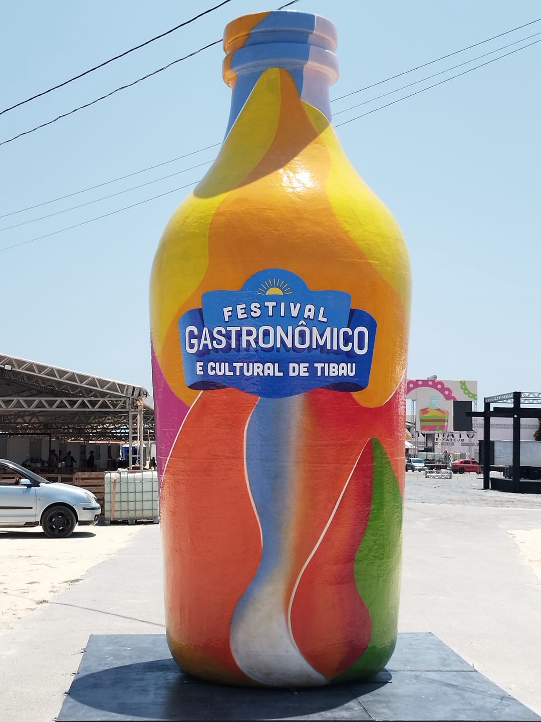 Escultura gigante de garrafa com areia colorida marca entrada do 5º Festival Gastronômico e Cultural de Tibau