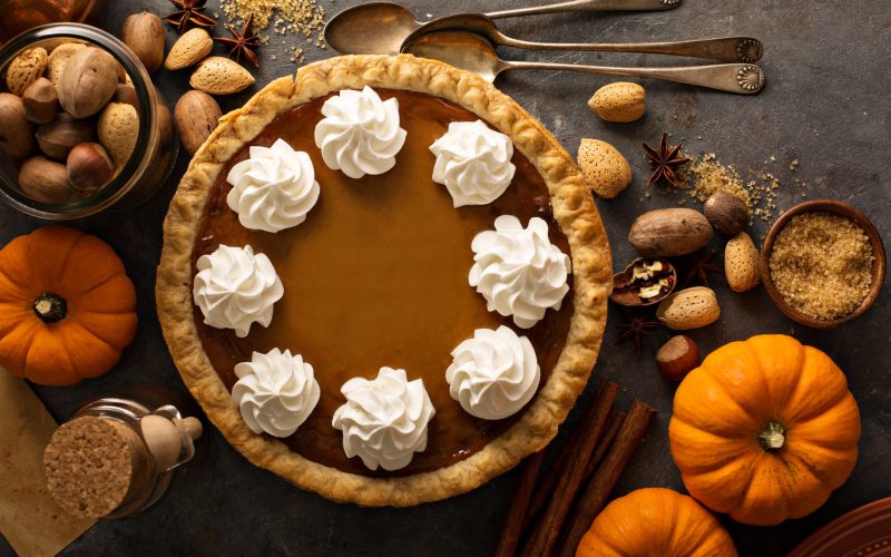 Sweet pumpkin pie decorated with whipped cream overhead shot with copy space