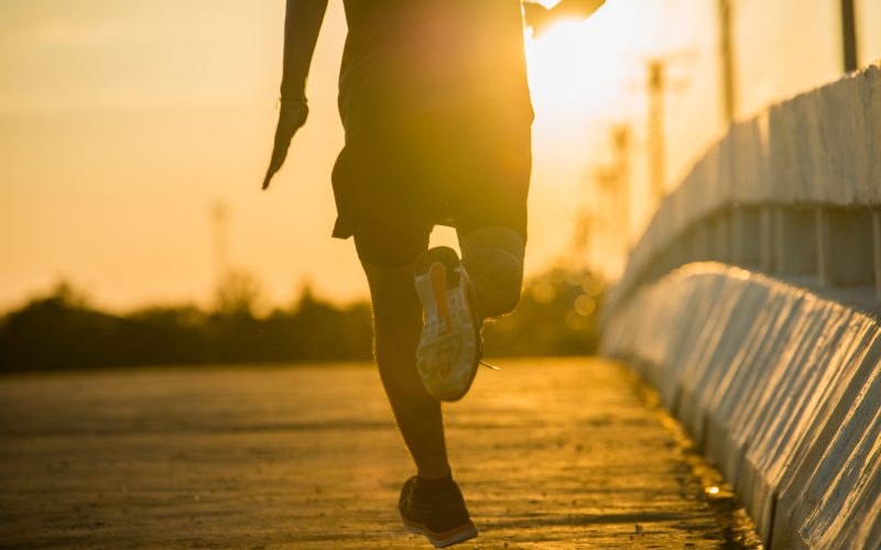 silhouette of a young fitness man running on sunrise