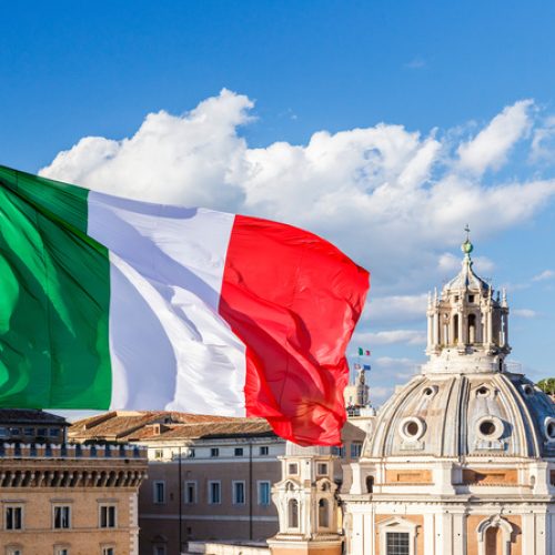 Italian flag on the background of the Cathedral and the blue sky