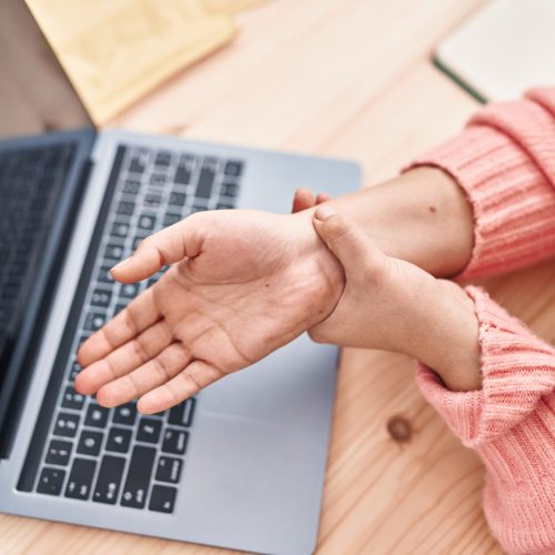 Young beautiful hispanic woman ecommerce business worker suffering for wrist pain at office